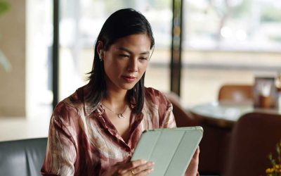 businesswoman sitting cafe table and reading article on tablet computer